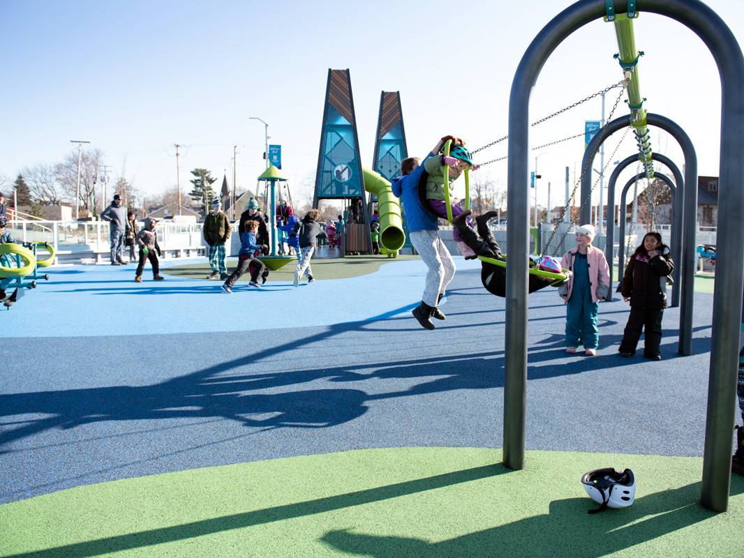 A kid swings on a swingset at the Howard Park Playground