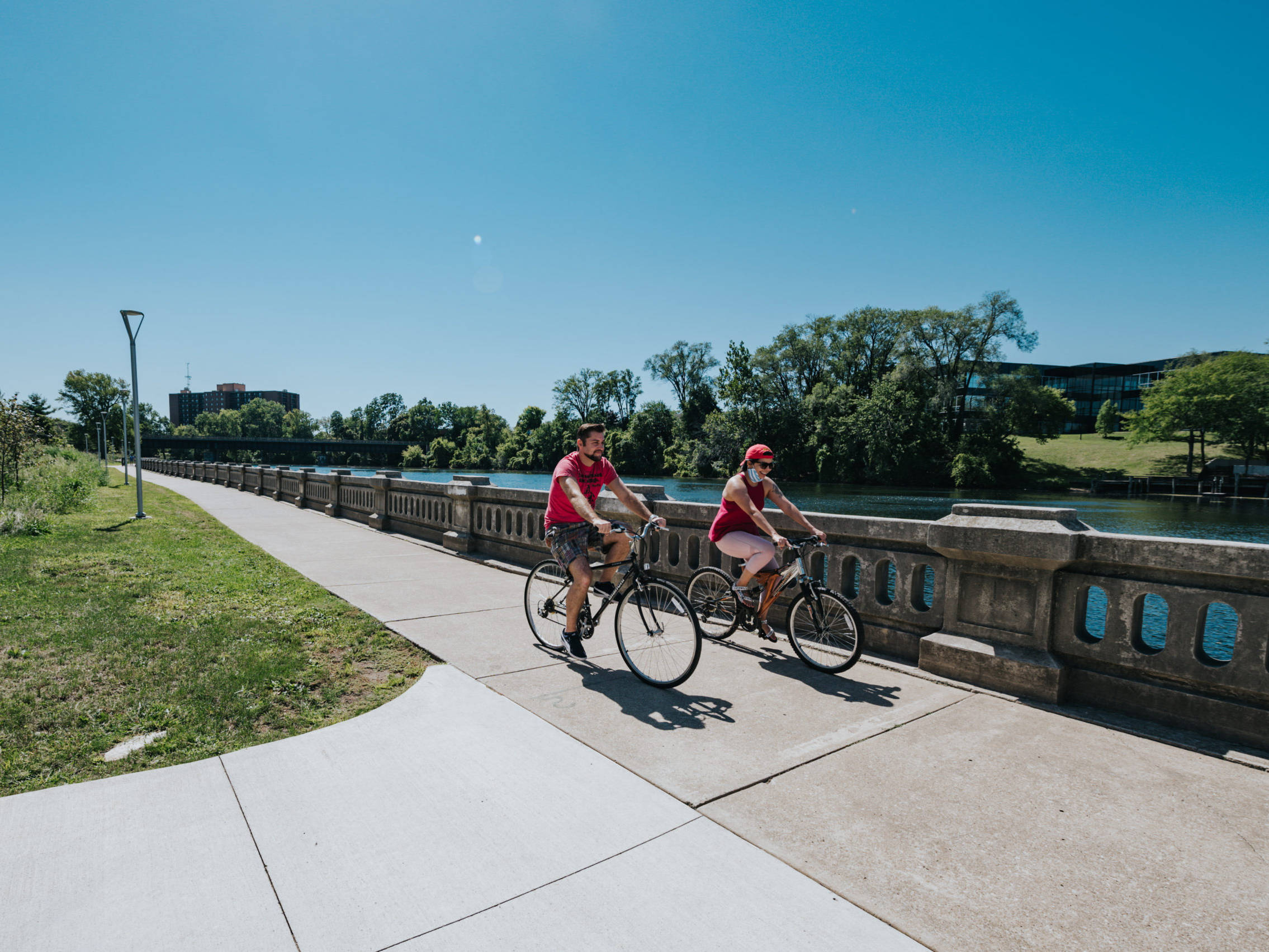 two bikers ride down the river walk
